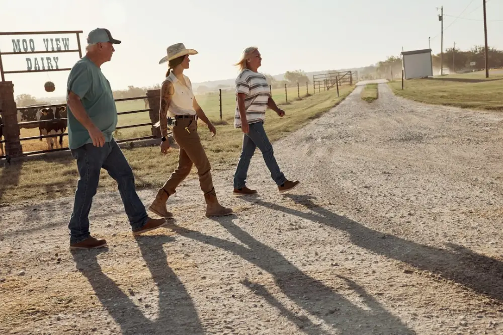 Three farmers walking across a farmyard, illustrating coordination across food-system participants